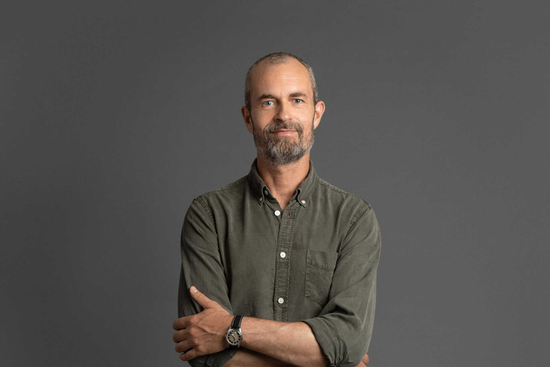 Confident male therapist with arms crossed, representing professional mental health support at Psykologhuset Konversa.